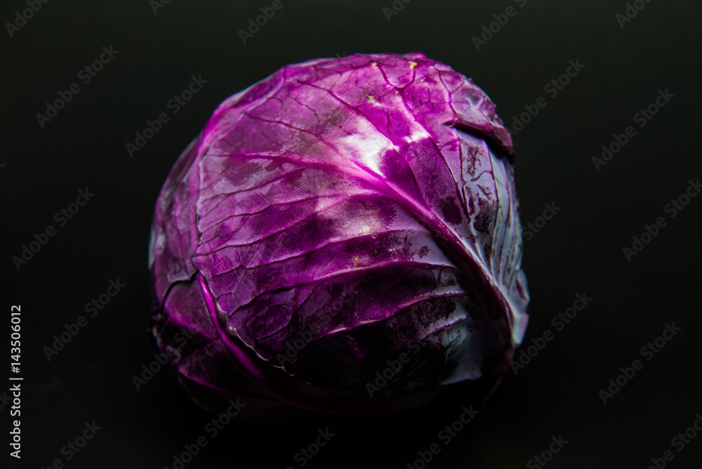 Obraz premium Fresh scotch kale or purple cabbage isolated on black background with selective focus and under exposre