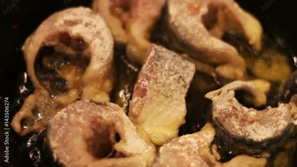 Pieces of freshwater fish frying in a cast-iron skillet. Pieces of freshwater fish frying in a cast-iron skillet.