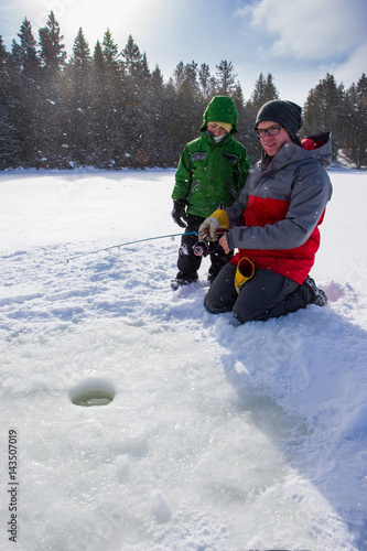 Mixed race family ice fishing