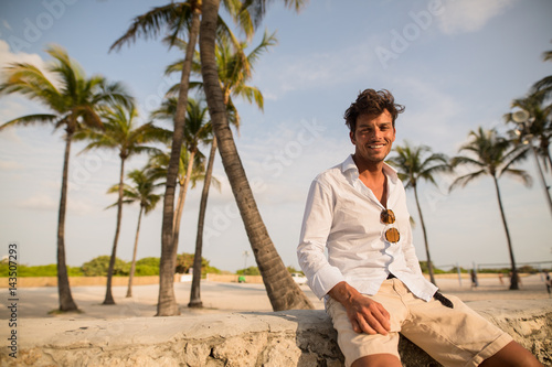 Guy sitting under the palms while sunset