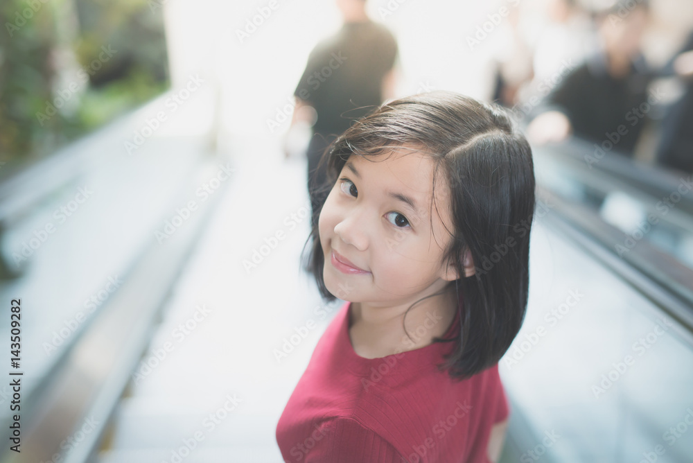 Asian girl standing on escalator Asian girl standing on escalator