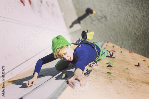 Rock climber reaching for his next hand hold, Joshua Tree National Park.