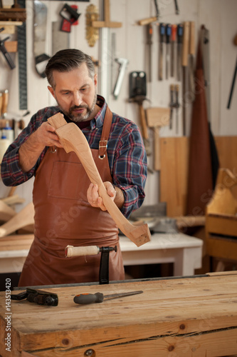 Exquisite Lines of the Cabriole's Legs/Carpenter works with a planer in a workshop for the production of vintage furniture. He makes cabriole leg for a table in the style of Louis XV and Queen Anne photo