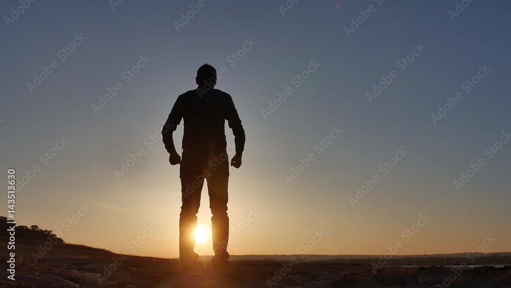 freedom. Man stands on a cliff sunset silhouette hand lifestyle in the sides