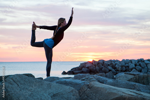 Woman Practicing Yoga on a Pier at Sunrise