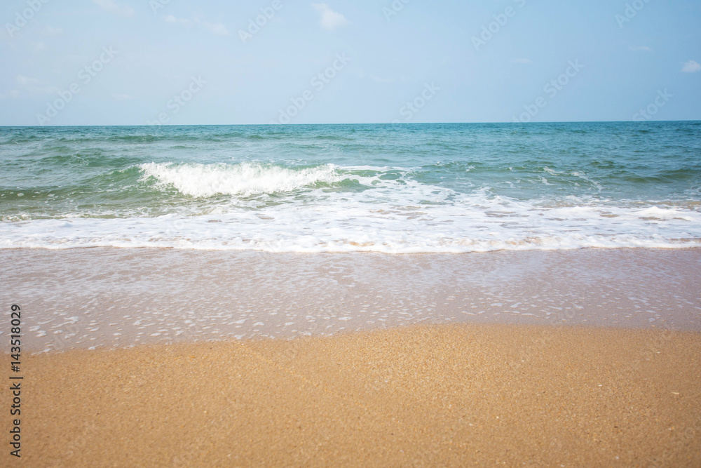 Soft wave of blue ocean on sandy beach at sunny day.
