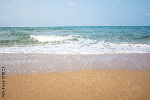 Soft wave of blue ocean on sandy beach at sunny day.