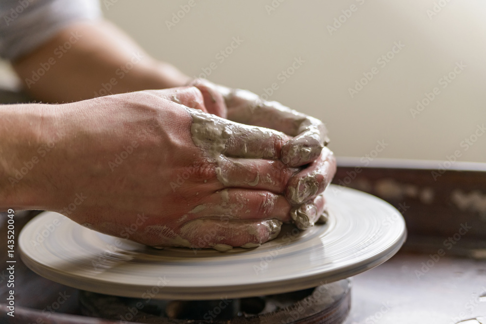 Hands working on pottery wheel