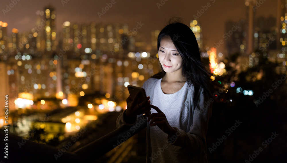 Woman use of mobile phone at night in Hong Kong Woman use of mobile phone at night in Hong Kong