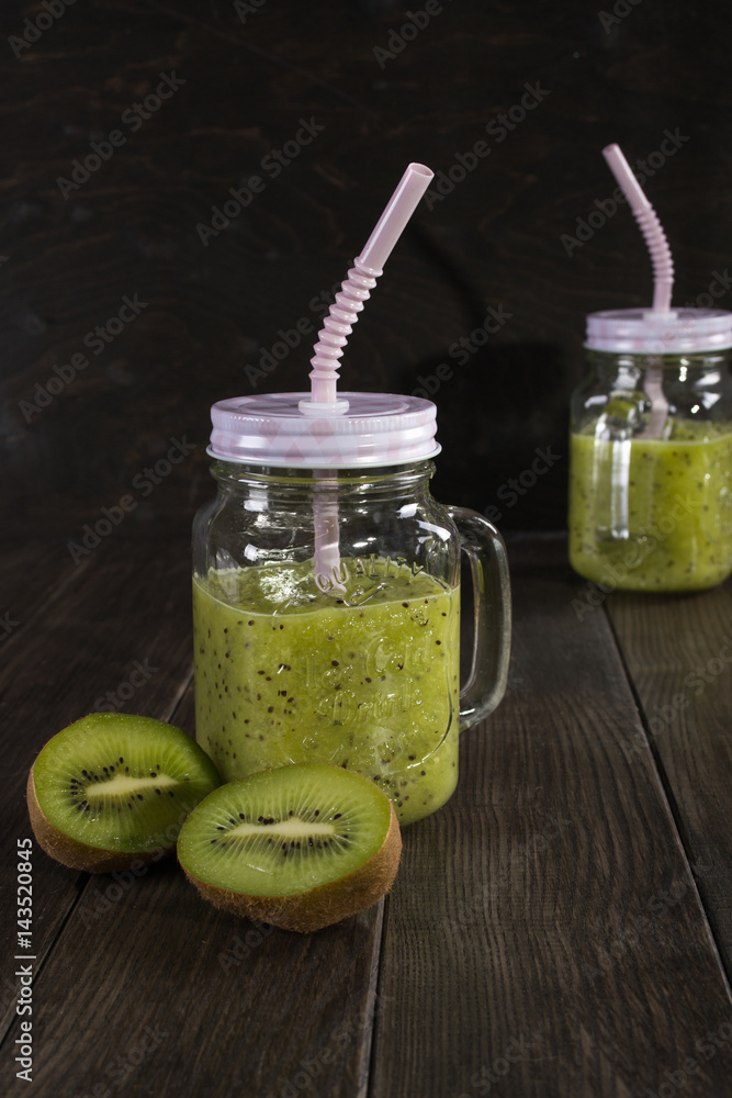 Fresh and healthy green Juice smoothie with kiwi in glass jar. On dark background Fresh and healthy green Juice smoothie with kiwi in glass jar. On dark background