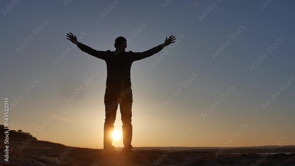 freedom. Man stands on a cliff sunset silhouette hand lifestyle in the sides