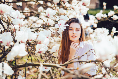 Portrait of beautiful woman with magnolia flowers. Spring time