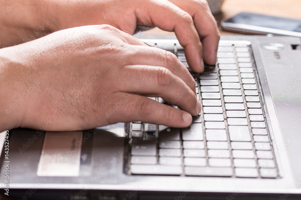 Adult mans hand on the keyboard of lap top Adult mans hand on the keyboard of lap top
