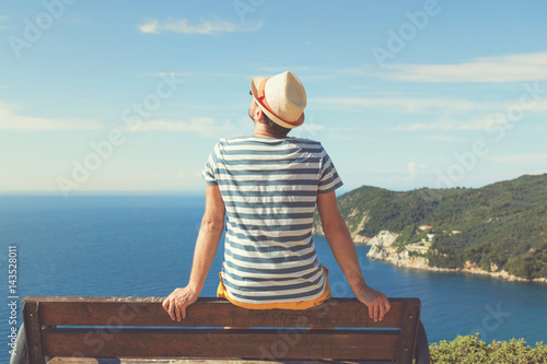 Man sitting on the bench and enjoying the view. Summer concept. © Kitja