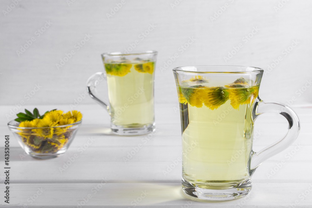 Two cups of herbal tea with coltsfoot (or Tussilago) flowers Two cups of herbal tea with coltsfoot (or Tussilago) flowers