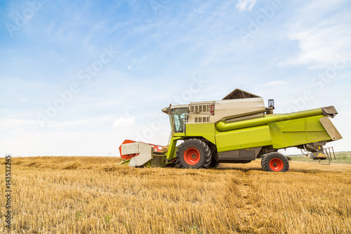 Combine harvester in action on wheat field. Harvesting is the process of gathering a ripe crop from the fields.