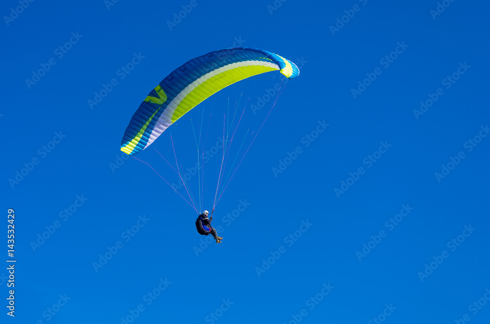 The paraglider flies in the blue sky The paraglider flies in the blue sky