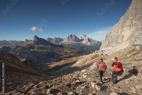 two climbers walking in the Mondeval area in Dolomites at evening after a climbing session