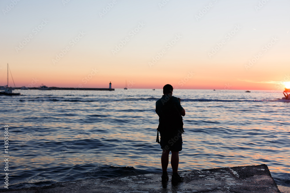 Mann blickt in Sonnenuntergang am Meer