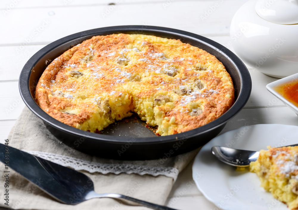 Slice of cheese casserole served with honey Slice of cheese casserole served with honey