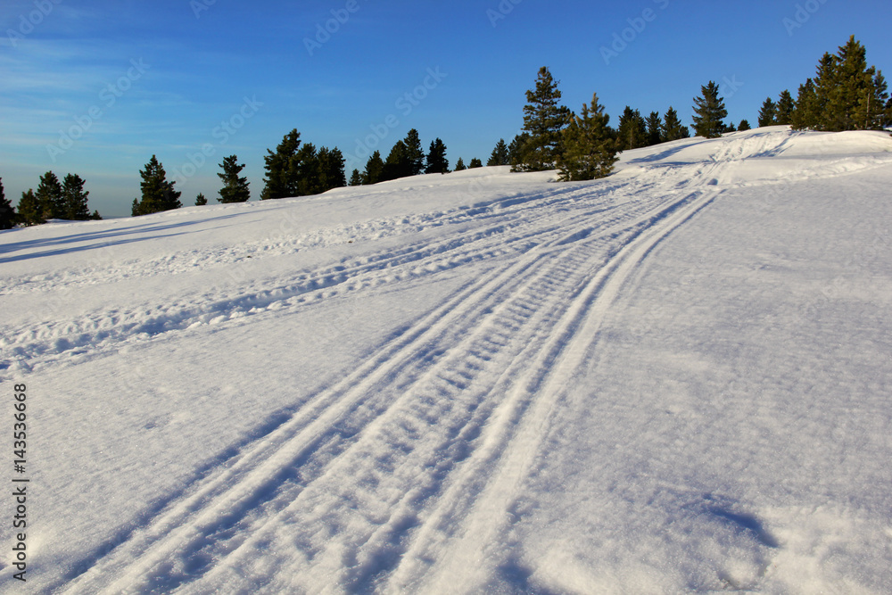 Snowmobile traces in blue mountains. Snowmobile traces