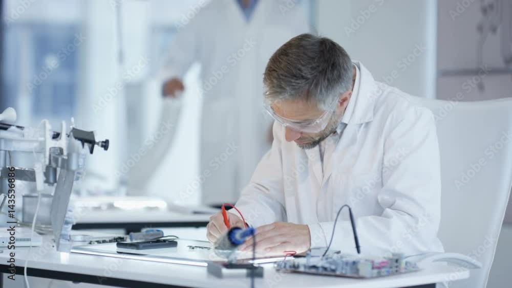 Electronics engineers working in lab building & testing electronic devices Electronics engineers working in lab building & testing electronic devices