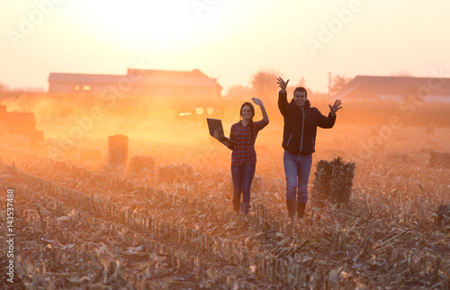 Happy farmers walking on field