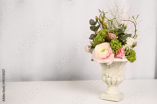 Antique vase with floral arrangement on white background, part of the interior, copy Space
