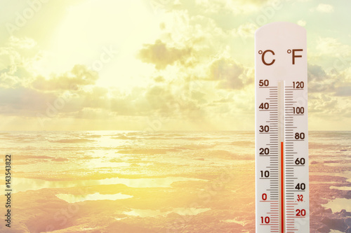 image of thermometer against sunset sky