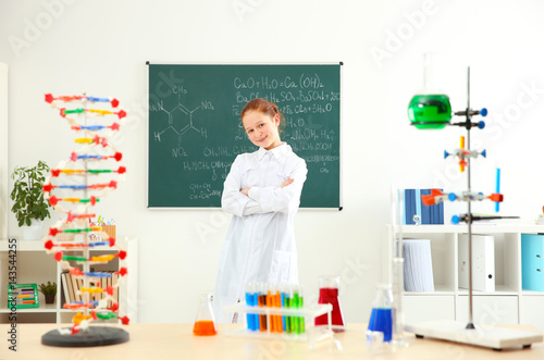 School girl standing at blackboard in chemistry class © Africa Studio