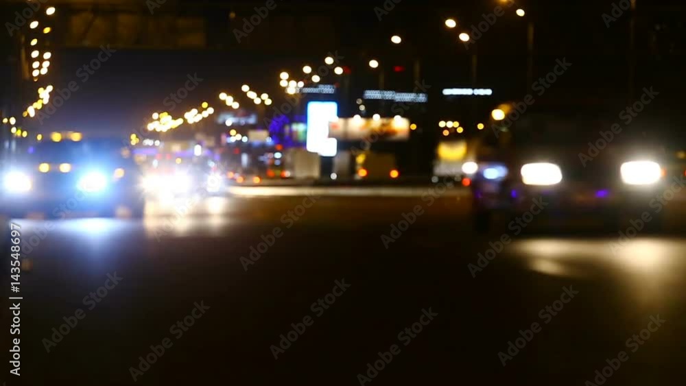 Night city traffic light. Cars are driving along the road. Blurred view Night city traffic light. Cars are driving along the road. Blurred view