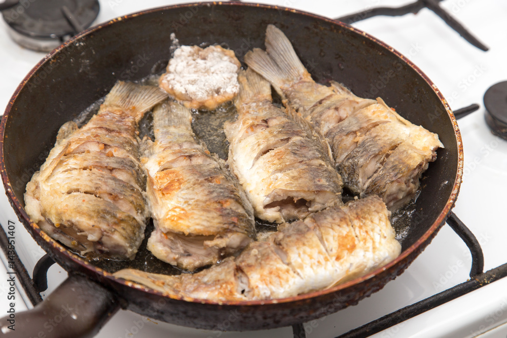 Fish carp is fried in a frying pan Fish carp is fried in a frying pan
