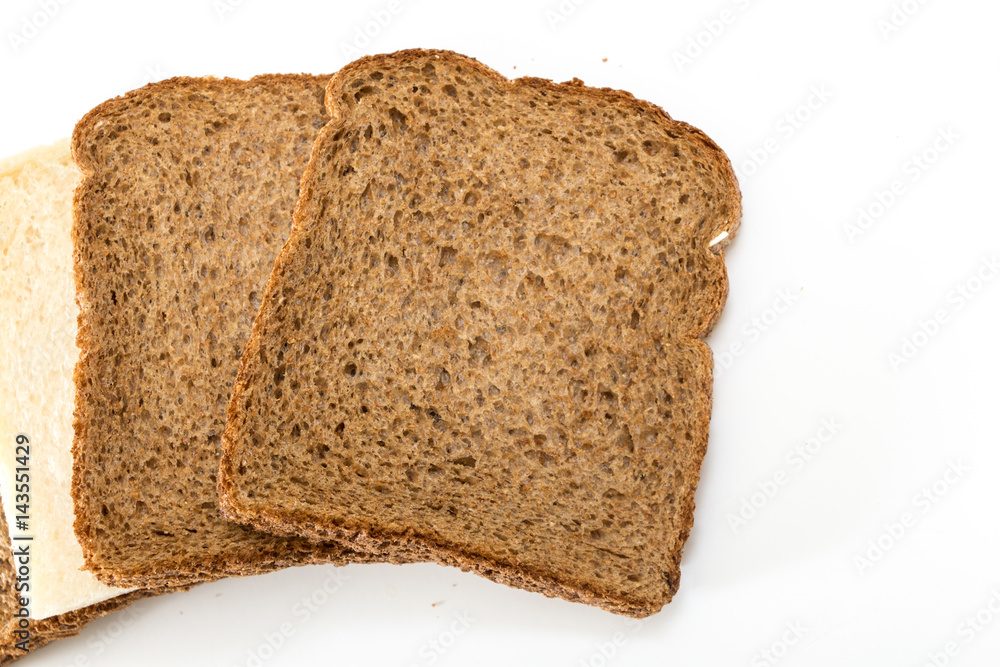 Whole grain sandwich bread slices with one white slice, on white background.