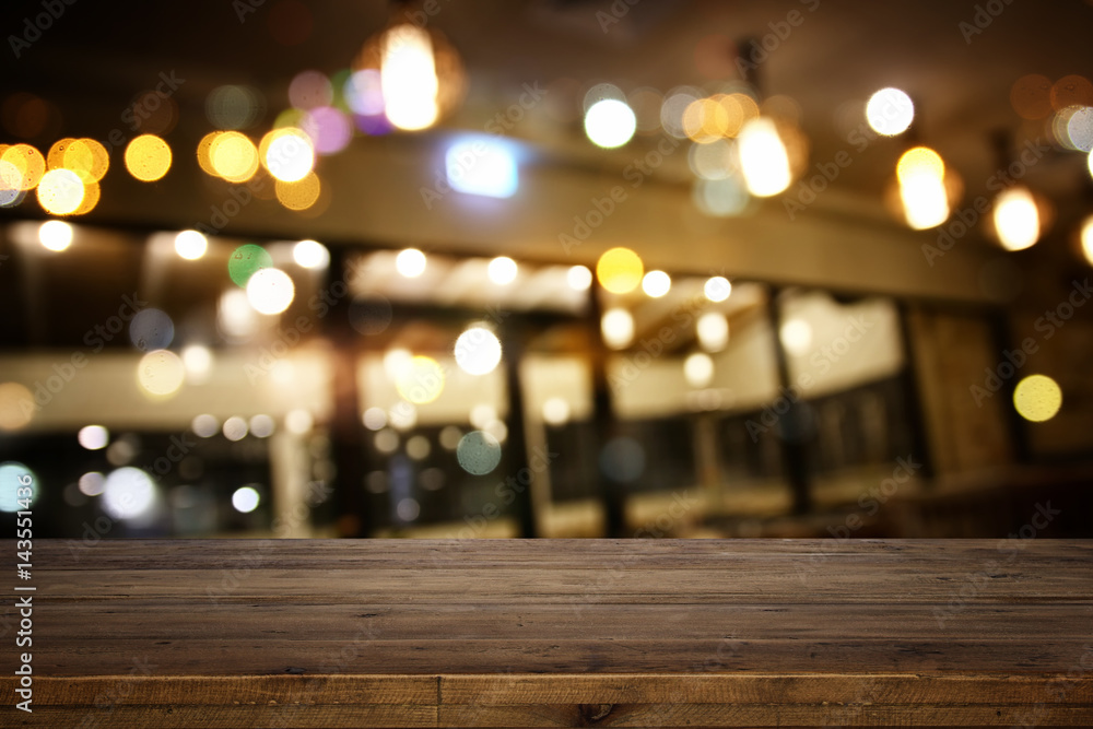 wooden table in front of abstract restaurant lights background