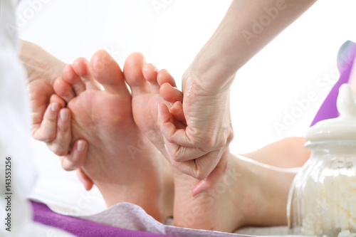 Relaksujący masaż stóp. Kobieta w salonie kosmetycznym na zabiegu pedicure z masażem.
