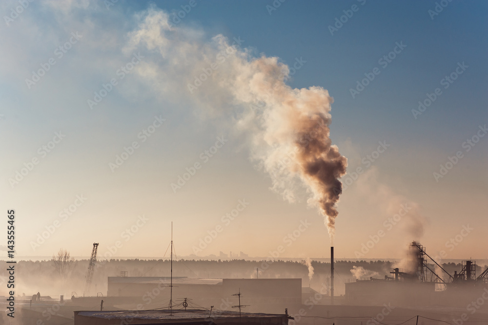 Industrial buildings in the fog on the blue sky backgrond. Warehouses. Smoke from the pipe. Smog. Industrial buildings in the fog on the blue sky backgrond. Warehouses. Smoke from the pipe. Smog.