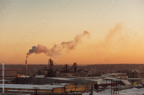 Industrial buildings at sunrise. Warehouses. Smoke from the pipe. Gradient.