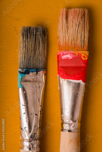 Paint brushes on the yellow background vertical
