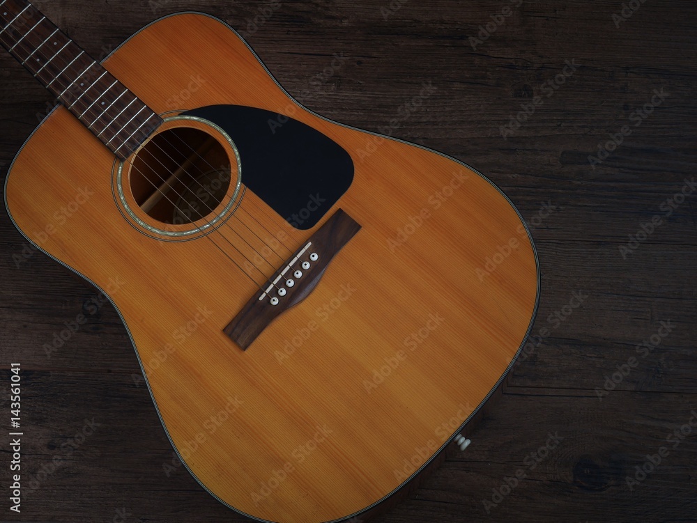 Fototapeta premium Vintage style closeup acoustic guitar on grunge wooden background