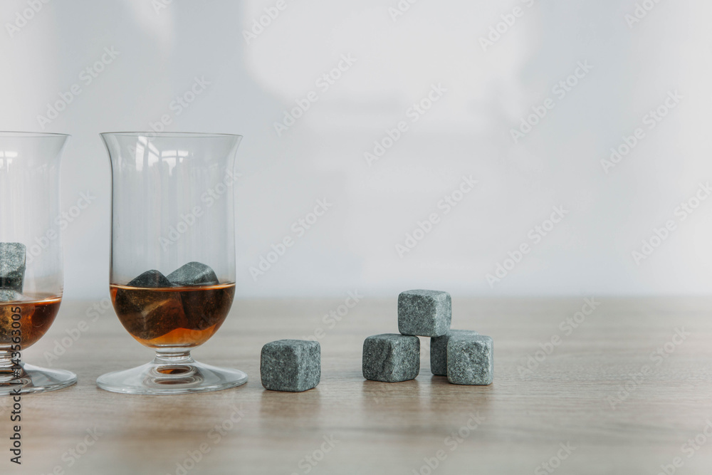 Stones for cooling whiskey and glases tulup on light wooden background Stones for cooling whiskey and glases tulup on light wooden background