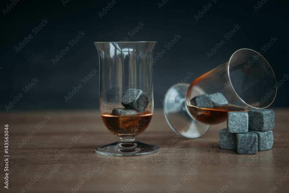 Stones for cooling whiskey and glases tulup on dark wooden background Stones for cooling whiskey and glases tulup on dark wooden background