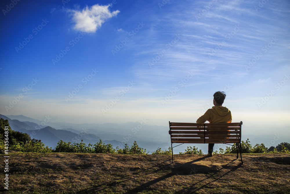 A man sitting on veranda and playing on tablet at view point. A man sitting on veranda and playing on tablet at view point.
