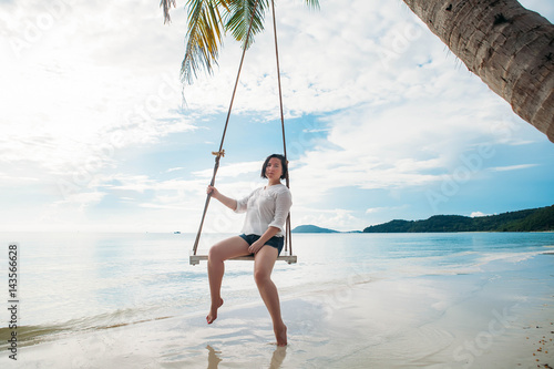 Happy woman on a swing tropical island