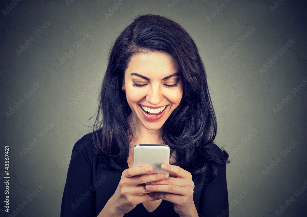 Laughing woman text messaging on smart phone having a pleasant chart conversation Laughing woman text messaging on smart phone having a pleasant chart conversation