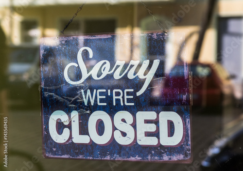 Sorry we're closed sign in a shop window