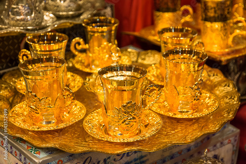 Set of traditional Turkish tea glasses on a golden tray photo