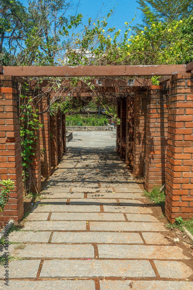 Obraz premium View of red brick pillar pathway in a garden, Chennai, India, April 1st 2017
