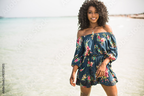 Fashion woman walking on beach with a summer dress