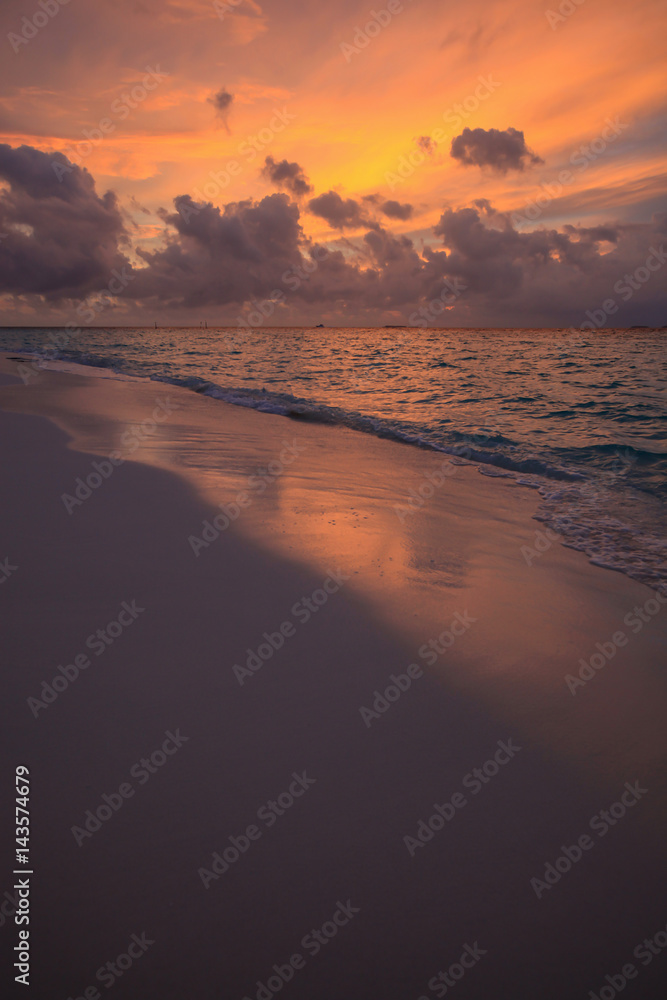 Sunset in clouds above sand coast of Indian ocean, Maldives