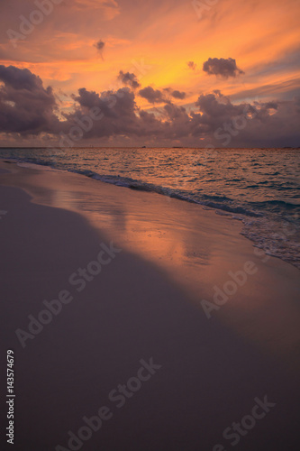 Sunset in clouds above sand coast of Indian ocean  Maldives